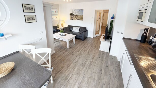 Un appartement moderne comprenant un coin repas, un salon et une cuisine.