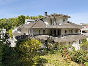 A two-story house with a balcony, surrounded by greenery. - MR: Villa Rosa Whg. 16 Sea magic with 2 roof terraces - Villa Rosa Whg. 16 (Sellin)