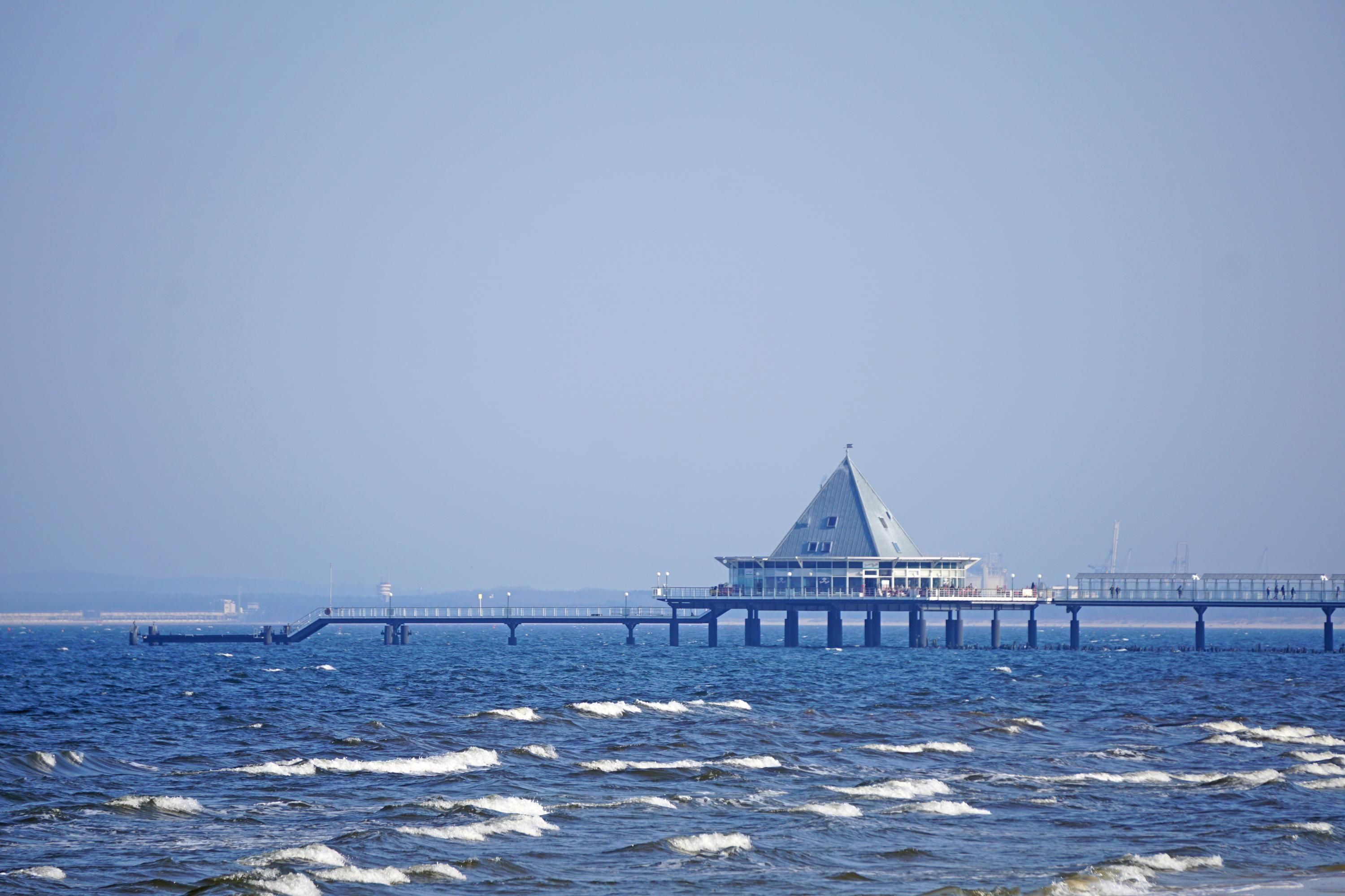 A pier extending into the water with a building at the end.