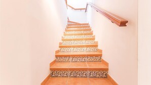 A staircase with ornate patterned tiles and wooden handrails.