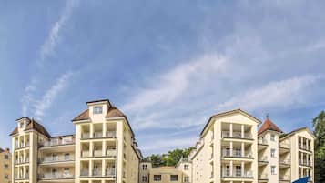 Ein mehrstöckiges Hotel mit Balkonen, blauem Himmel und einem Schild vor der Fassade.