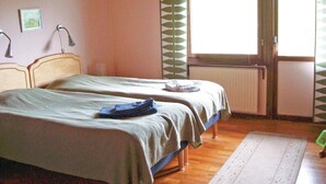 A room with two single beds, a radiator, a window with a view, and a green patterned curtain. - Cozy home in Strängnäs with sauna (Strängnäs)