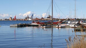 A harbor with various boats docked, a prominent church in the background, and calm water reflecting the boats.