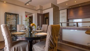 Un comedor moderno con una mesa redonda dispuesta para cuatro personas, rodeada de sillas acolchadas.