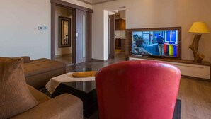 Una sala de estar moderna con una televisión, una silla roja y una mesa de centro.