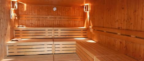 Una sauna de madera con bancos y luces en la pared.