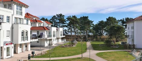 A hotel with multiple white buildings, red roofs, and a central pathway.