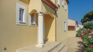 A yellow building with white window frames and a white column in front.