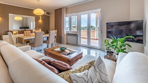 Una sala de estar moderna con un sofá, una mesa de centro y un comedor con sillas y una mesa.