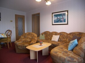 Sala de estar com sofá, mesa de centro e quadro na parede.