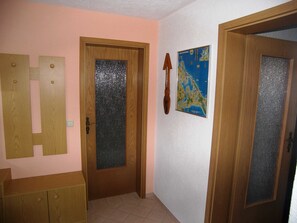 Um corredor com portas de madeira, um mapa na parede e um armário de madeira.