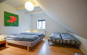 Cozy retreat with a single bed, bedside table, and potted plant.