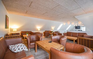 Relax in a stylish room with leather sofas, a coffee table, and a flat-screen TV.