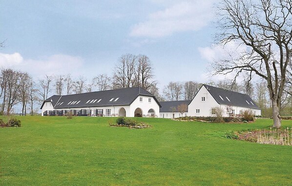 Stunning building with a central arched section and smaller windows, set amidst a beautifully manicured lawn.