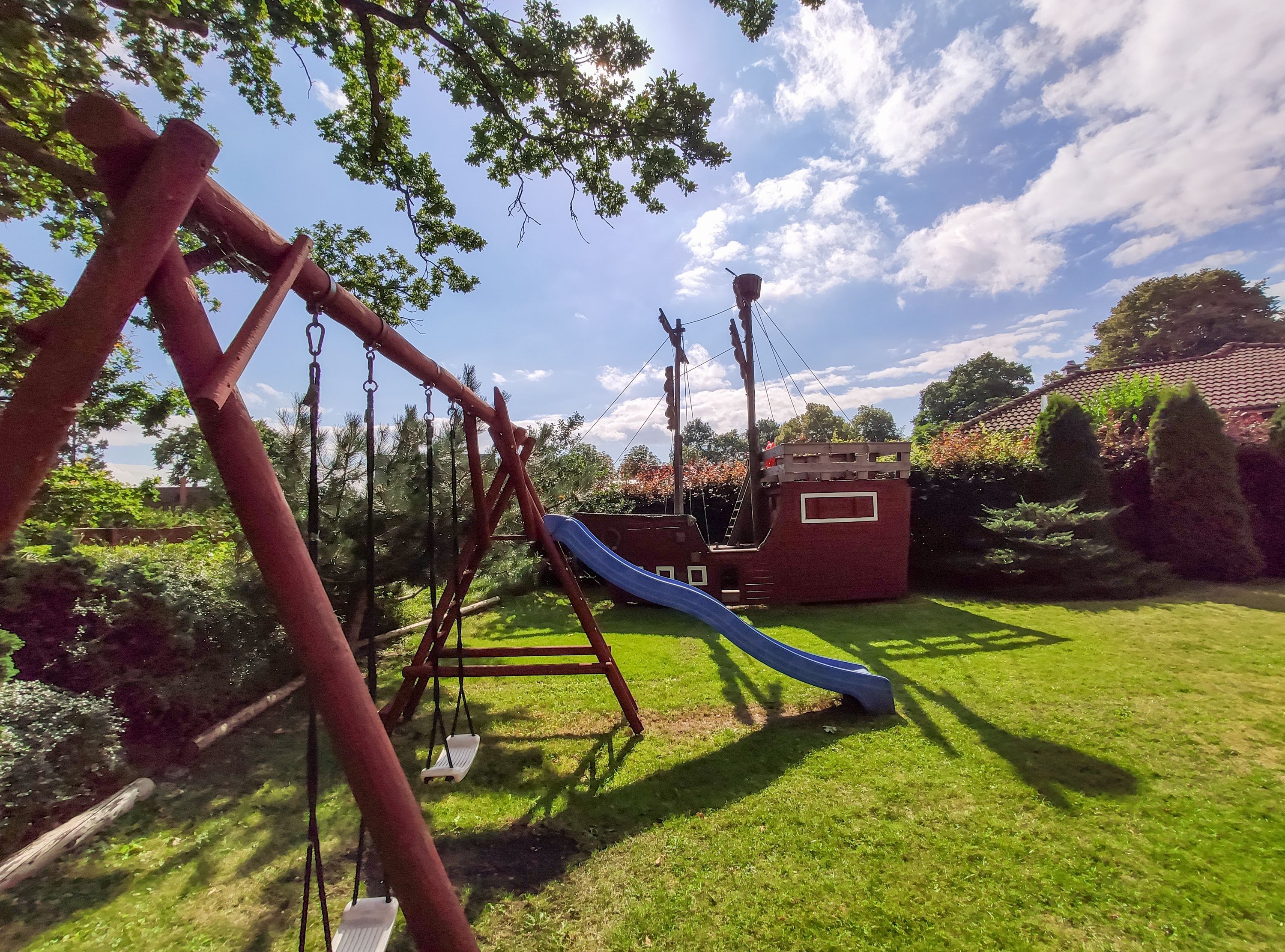 Un parque infantil con columpios, tobogán y estructura para escalar.