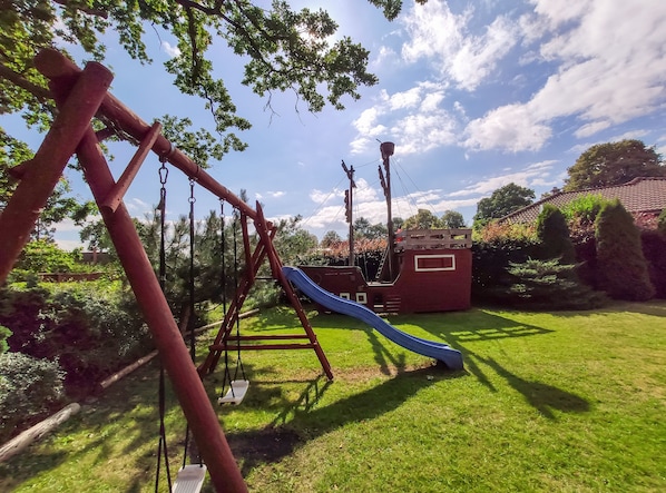 A playground with swings, a slide, and a climbing structure.