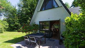 A house with a patio, a dining table, and chairs.