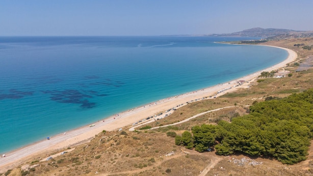 A coastal beach with clear blue waters, a sandy shore, and a road running parallel to the beach. - Beach front home in Ribera (AG) (Ribera (AG))