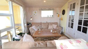 Un salon confortable avec un canapé, une table basse et une fenêtre.