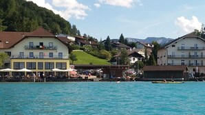 Un hôtel situé au bord de l’eau, composé de plusieurs bâtiments, doté d’un quai et offrant une vue sur un paysage montagneux.