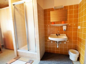 A bathroom with a shower, sink, and toilet.