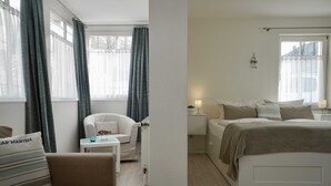 A hotel room with a bed, a chair, a small table, and a nightstand. - 07 Ferienappartement Mönchgut (H) - Apartment house Haus Arkona (Sellin)