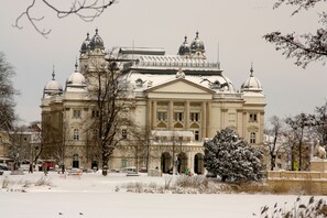 Un grand bâtiment historique doté de plusieurs dômes et d’une entrée centrale.