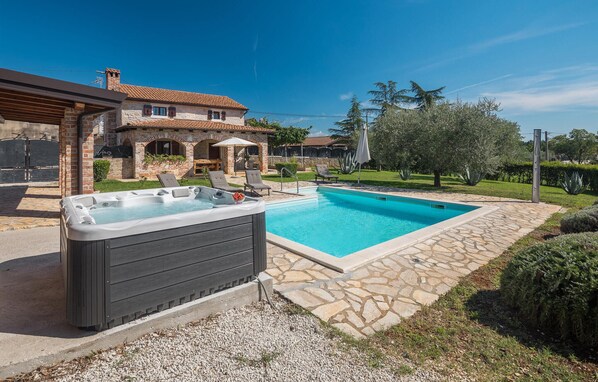 Relax by the pool with a hot tub and lounge chairs.