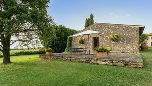 A stone building with a patio, outdoor seating, and potted plants. - 3 bedroom beautiful home in Ischia di Castro -VT- (Ischia di Castro -VT-)