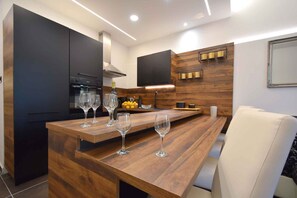 Enjoy dining and entertaining in this stylish kitchen with a central island, cabinets, and a flat-screen TV.