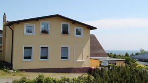 A two-story building with multiple windows and a visible number '21'. - Bungalow - Holiday Rentals Liliane (Göhren)