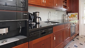 A kitchen with a built-in microwave, coffee maker, sink, and dishwasher.