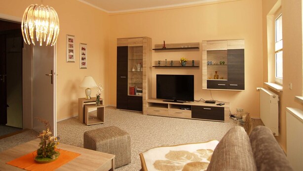 A modern living room with a flat-screen TV, wooden entertainment unit, and a cozy seating area. - KR-07 - Karl-Risch-Str. 7 units. Above. (Kühlungsborn)