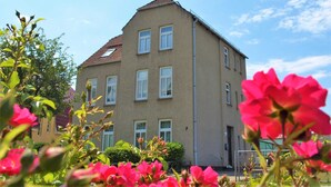 A multi-story building with a symmetrical facade, multiple windows, and a visible entrance. - KR-07 - Karl-Risch-Str. 7 units. Above. (Kühlungsborn)