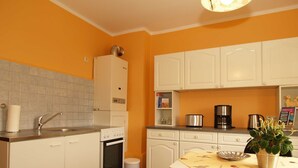 A compact kitchen with white cabinets, a sink, a stove, and a coffee maker. - KR-07 - Karl-Risch-Str. 7 units. Above. (Kühlungsborn)