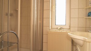 A bathroom with a shower, a sink, and a window. - KR-07 - Karl-Risch-Str. 7 units. Above. (Kühlungsborn)