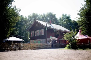 A wooden building with a porch, a bicycle, and a sign. - Spring - Room 1 - Forsthaus Leiner Berg (Dessau-Roßlau)
