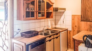 A kitchen with wooden cabinets, a dishwasher, a sink, and a kettle. - Pet friendly apartment in Retowo 4 (Retowo 4)