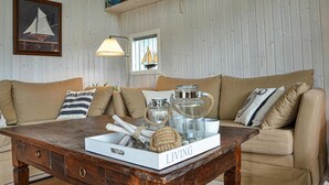 Ett mysigt vardagsrum med ett soffbord i trä, en beige soffa och dekorativa föremål.