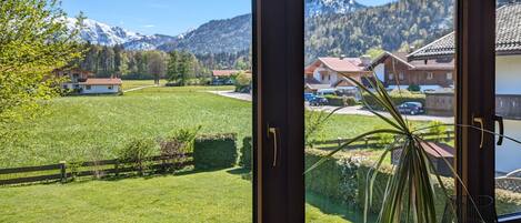 A room with large windows overlooking a green landscape and mountains.