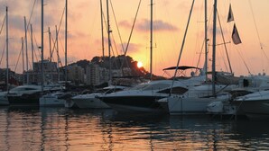 Ein Yachthafen im Abendlicht mit mehreren vertäuten Segelbooten.