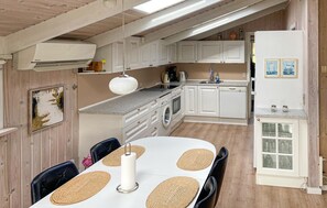 A compact kitchen with white cabinets, a built-in oven, and a sink.