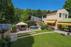 Een villa met zwembad, buitenterras en een verzorgde tuin.
