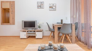 A modern living room with a wooden desk, a flat-screen TV, a dining area with chairs, and a decorative plant. - 1 bedroom beautiful apartment in Vodice (Vodice)