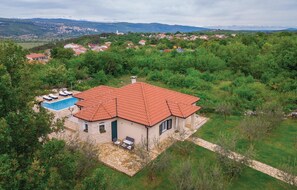 Set amidst lush greenery, this property offers a pool and outdoor seating area with views of the nearby town and mountains.