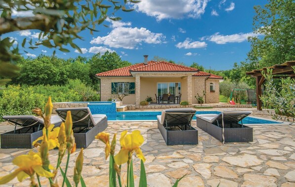 Relax by the serene pool surrounded by lush greenery and trees.