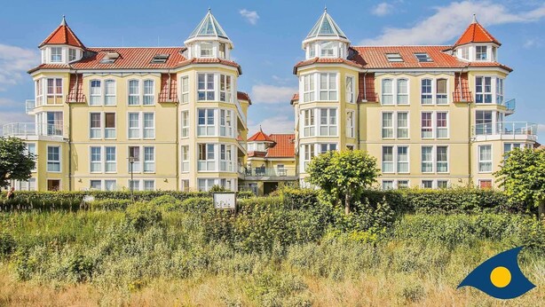 A large, yellow building with multiple windows and red-tiled roofs, surrounded by greenery. - Dune Residence B 05 - DR B 05 (Heringsdorf)