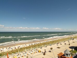Un hotel sul lungomare con posti a sedere all'aperto e vista sull'oceano, affacciato su una passeggiata.