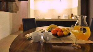 A dining table with a fruit bowl, two cups, a pitcher of orange juice, and a wine glass. - Holiday home for nature lovers in a quiet location (Buzet)