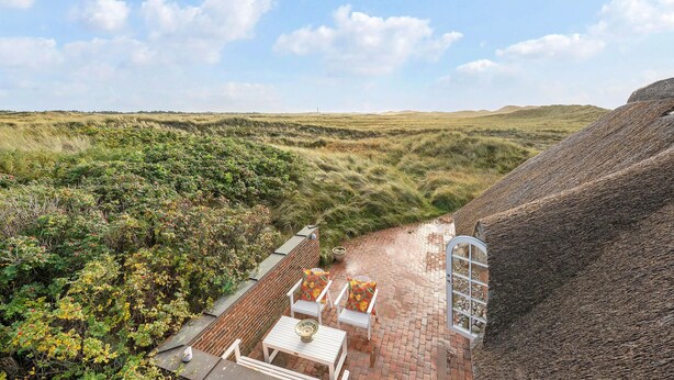 A view of a building with a brick exterior and a window overlooking a grassy landscape. - Beautiful home in Ringkøbing with WiFi (Ringkøbing)